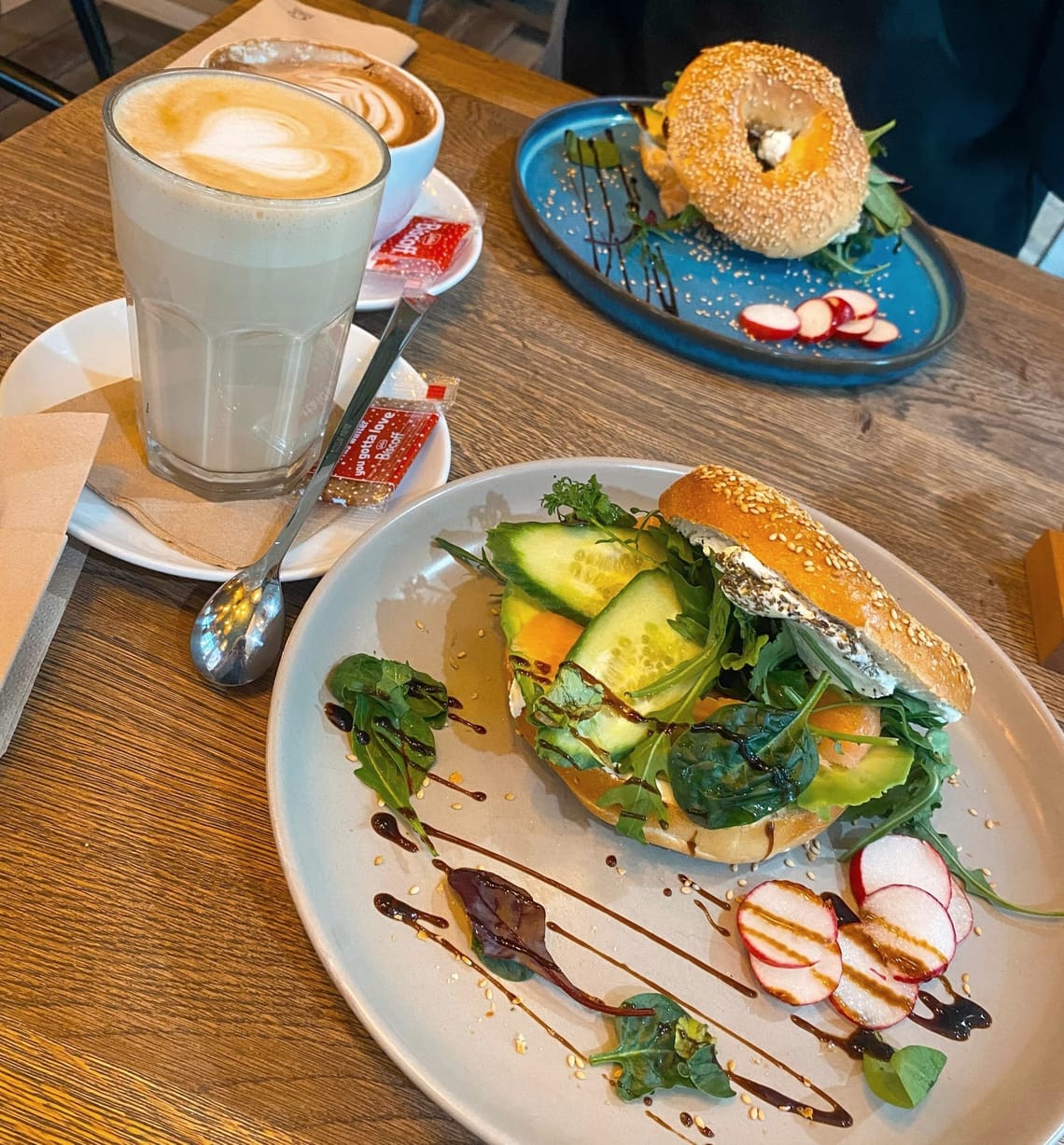 Salmon Avocado Bagels next to a latte macchiato at Coffee Brew Krefeld